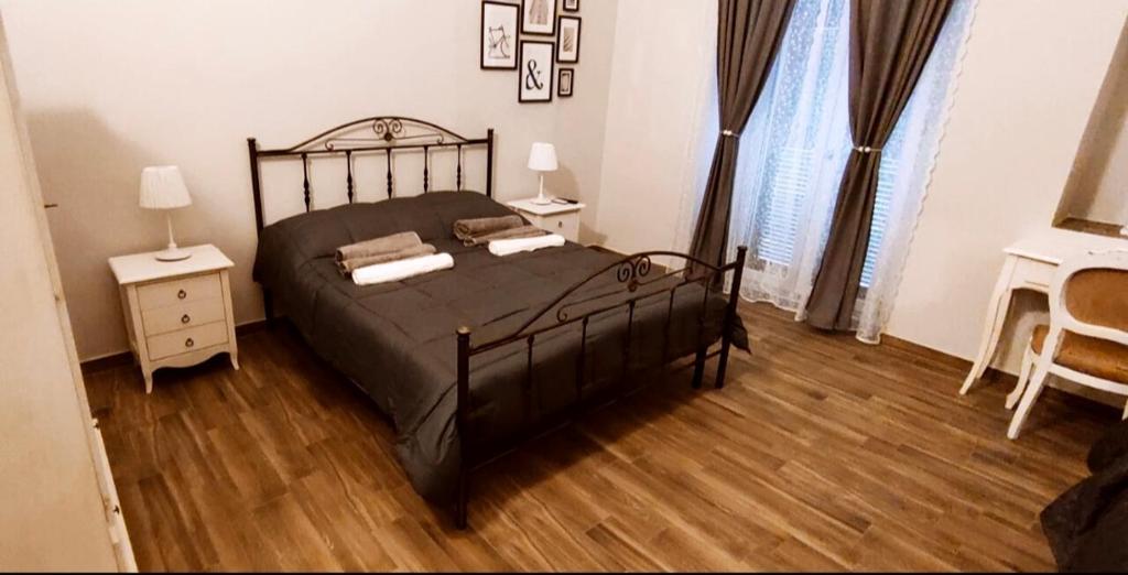 een slaapkamer met een zwart bed en een houten vloer bij Casa Principe Taranto "Intero appartamento" in Taranto