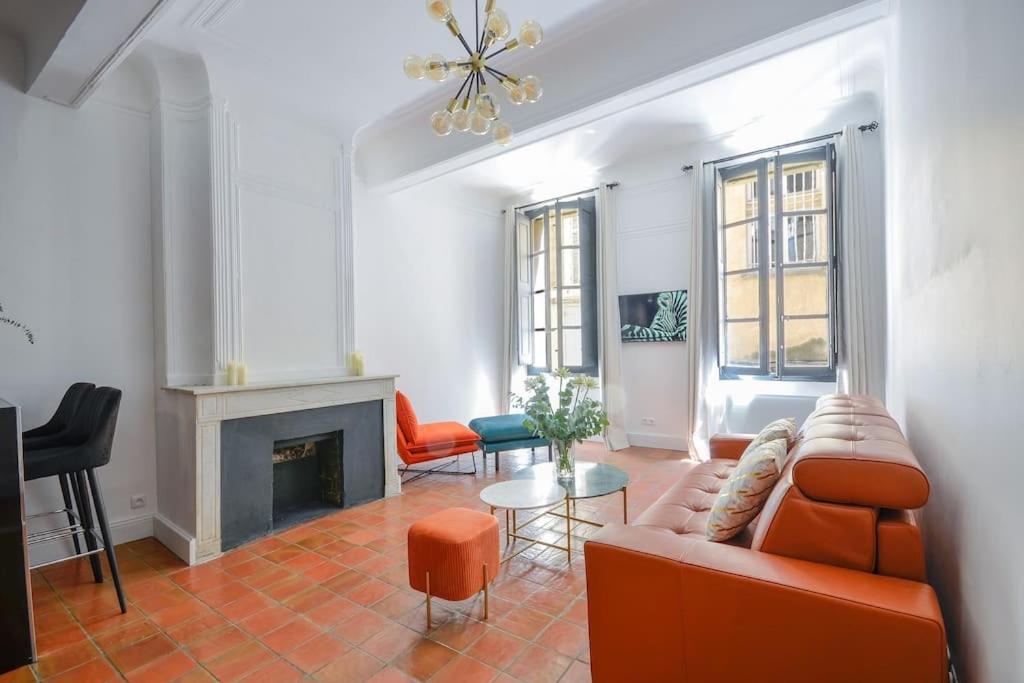 un salon avec un canapé et une cheminée dans l'établissement Élégant Appartement Standing à 3min du Cours Mirabeau, à Aix-en-Provence
