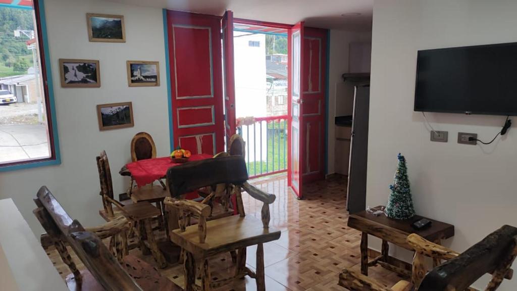 a dining room with a table and chairs and a television at Vivienda Turística Ángel R2 in Salento