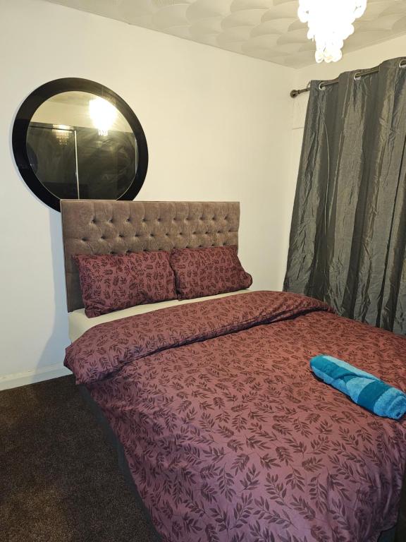 Un dormitorio con una cama grande y un espejo. en London Serviced Accommodation x RM10 x DM 4 Weekly x Monthly Deals x Sleeps 10 x FREE Parking x FREE Wifi E, en Dagenham