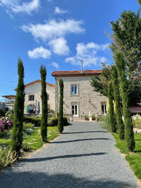 une allée menant à une maison en pierre avec des arbres dans l'établissement Le Domaine de la plume, à La Gimond