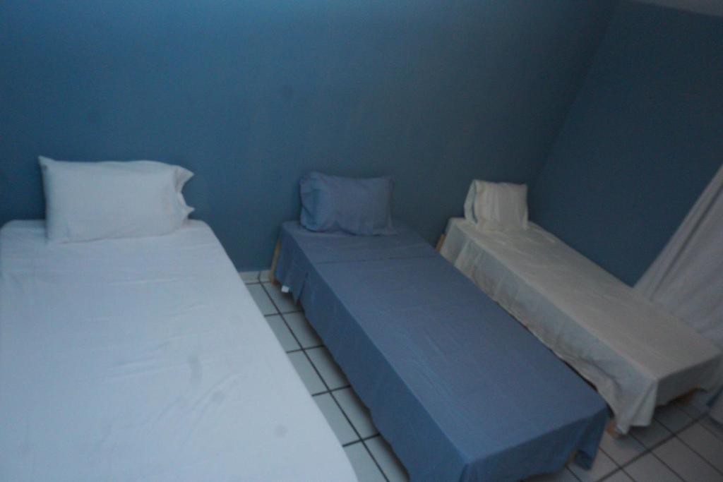 two beds in a room with blue walls at Habitación con tres camas in Tonalá