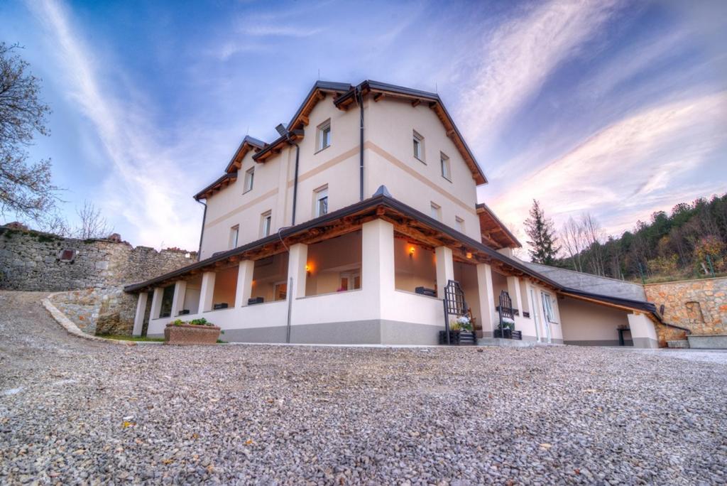 um grande edifício branco no topo de uma estrada rochosa em Dobra Hiša Zdravja Čičarija em Golac