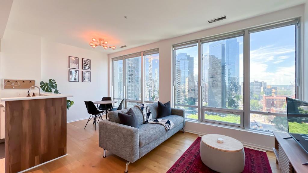 a living room with a couch and large windows at Stunning 1-Bedroom Condo in the Heart of Vancouver in Vancouver