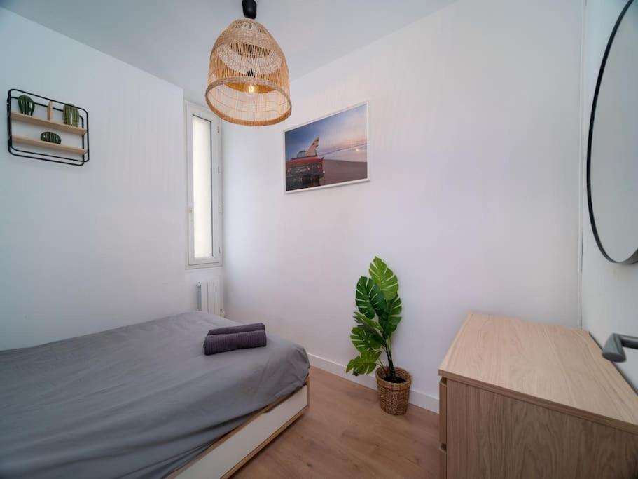 une chambre avec un lit et une plante en pot dans l'établissement Paradis en ville, à Marseille