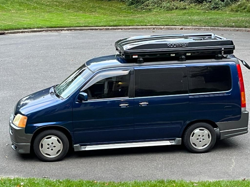 a blue minivan with a roof rack on a street at AllyouneedVan in Steinway