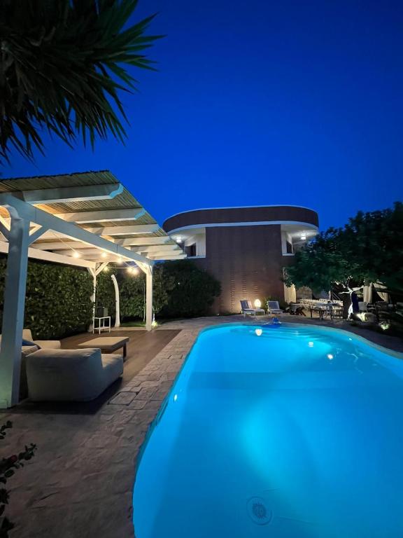 a swimming pool in front of a building at night at Kalè in Giovinazzo