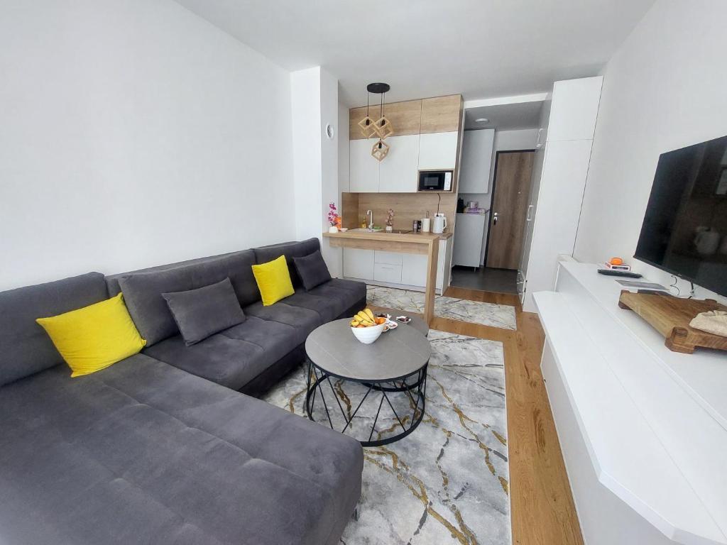 a living room with a couch and a table at Merak Bjelasnica in Bjelašnica