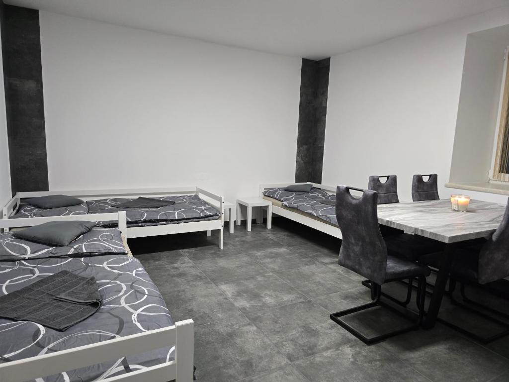 a room with two beds and a desk and a table at Rentcenter79 in Donawitz