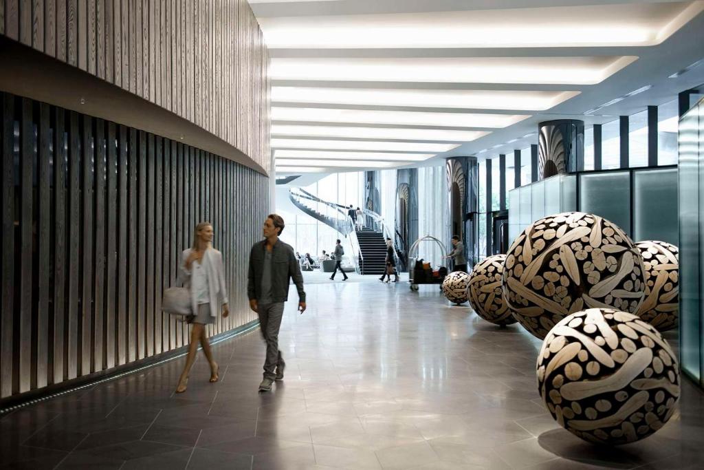 a man and woman walking through a building with balls at Crown Metropol Melbourne in Melbourne