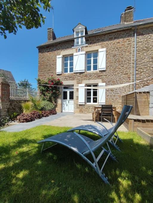 une chaise de jardin devant une maison en briques dans l'établissement Maison de bourg Bord de Rance Proximité des plages, à Pleudihen-sur-Rance