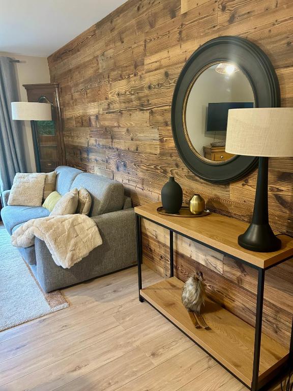 un salon avec un canapé et un miroir dans l'établissement Appartement style chalet avec grande terrasse et parking prive, à Chamonix-Mont-Blanc