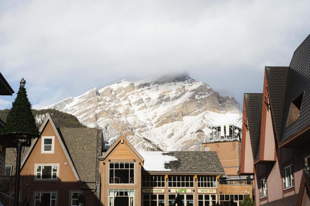 a snow covered mountain in the background of a city at Basecamp Suites Banff in Banff