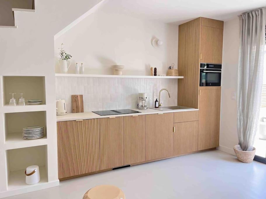 une cuisine avec des armoires en bois et un four à plaques de cuisson dans l'établissement LA GRANDE JANE petite villa bord de mer, à Borgo