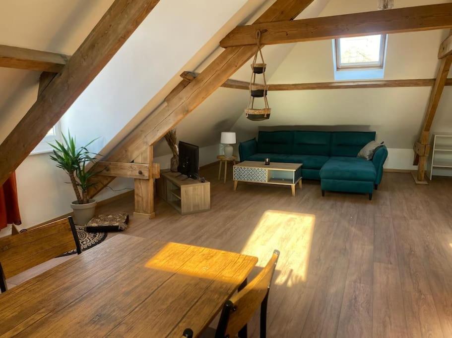 un salon avec un canapé vert et une table dans l'établissement Appartement proche plage, à Dunkerque