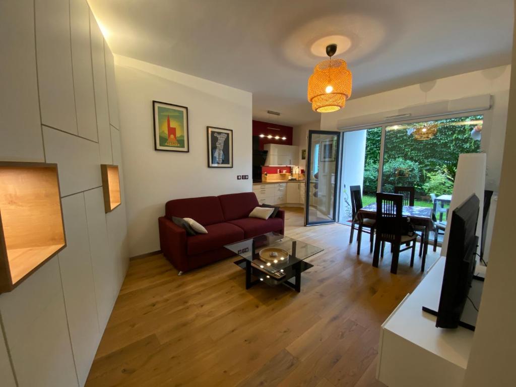 un salon avec un canapé rouge et une table dans l'établissement Strasbourg 3 pièces 
