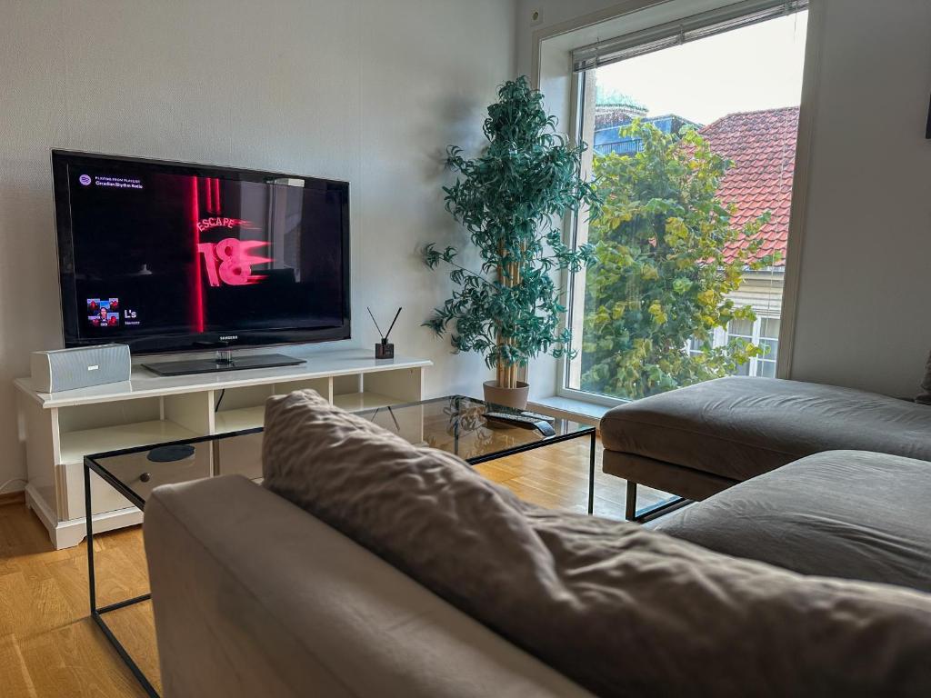 a living room with a couch and a flat screen tv at Hjertet av Stavanger in Stavanger