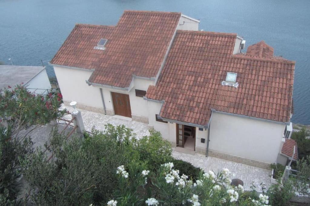 a house with two red roofs on top of it at Apartments Luxury apartments in Ploče