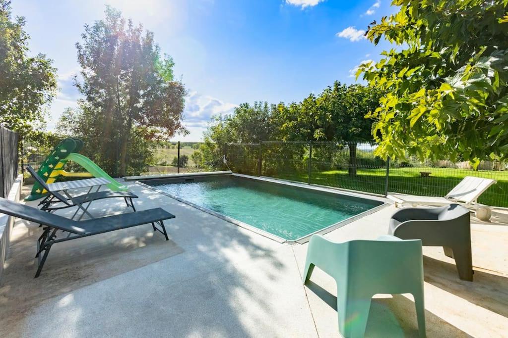 une piscine avec deux chaises et une balançoire dans l'établissement Villa t4 à la campagne, à Belleserre