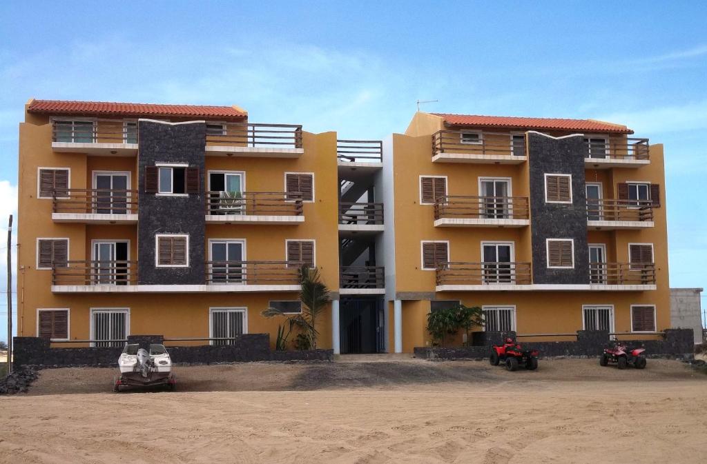 a building on the beach with motorcycles in front of it at Studio Mira Mare in Sal Rei