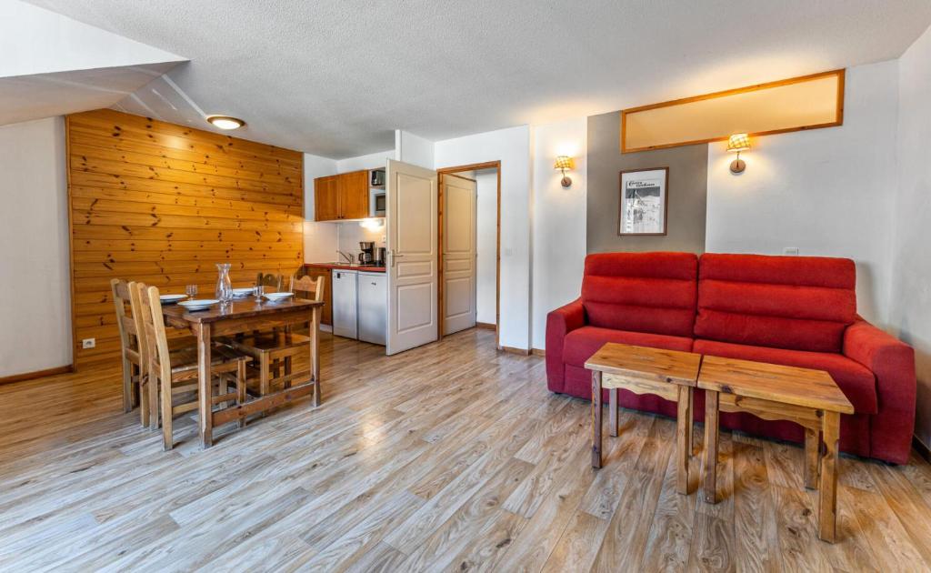 un salon avec un canapé rouge et une table dans l'établissement Résidence Les Hauts De Preclaux - Studio cosy au coeur des Orres 1800 MAE-4441, aux Orres