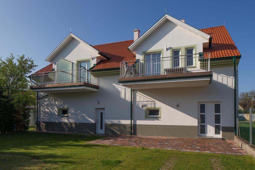 ein Haus mit zwei Balkonen und einem Hof in der Unterkunft Illmitzer Weinhof Haider in Illmitz