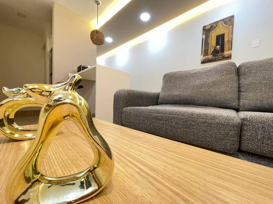トゥルムにあるGaia Condo de Lujo cómodo y tranquilo en ALDEA ZAMAのソファとテーブルの上に金色のアイテムが置かれたリビングルーム
