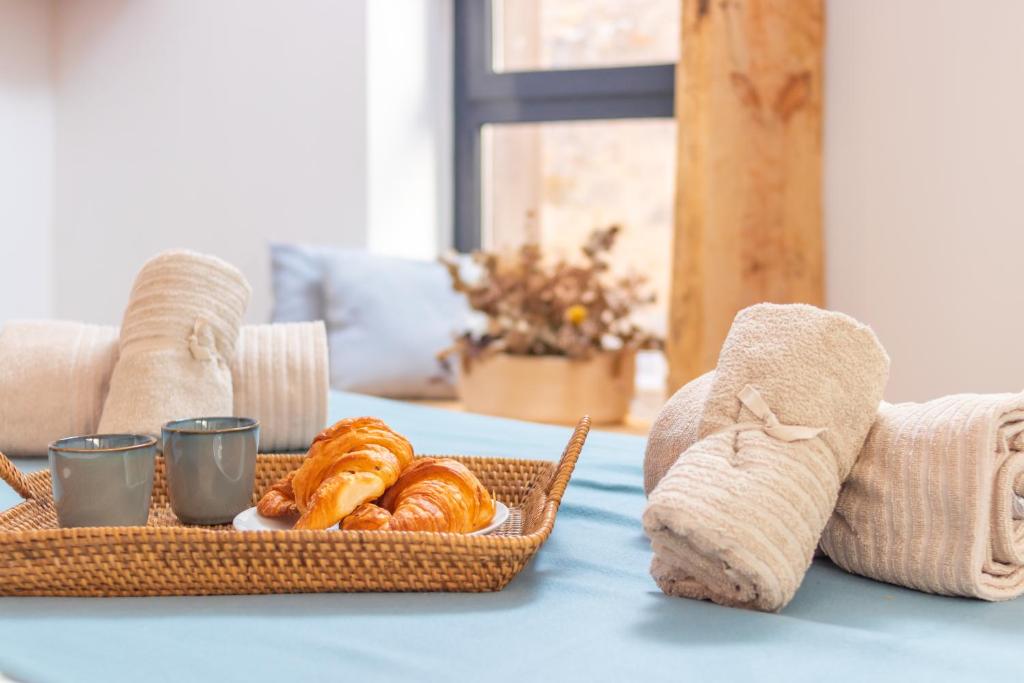 a table with a basket of pastries on a table at Eco-Apartament Costa Brava in Sant Jordi Desvalls