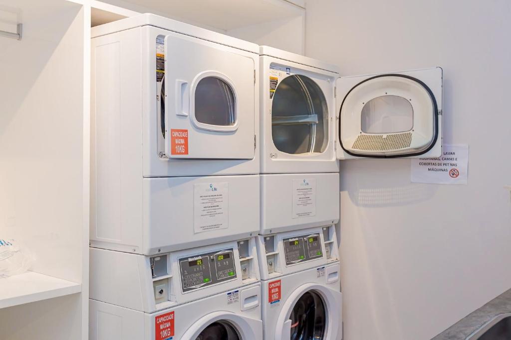 two washer and dryer machines in a room at Edificio Easy Life | Mercês - Curitiba | Gonzaga Stays in Curitiba