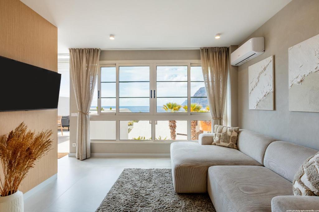 a living room with a couch and a large window at Stylish family home in Los Gigantes in Santiago del Teide