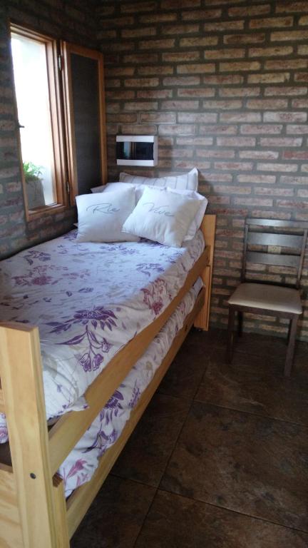 a bedroom with a bed with a chair and a window at Casa de Descanso. in Villa María