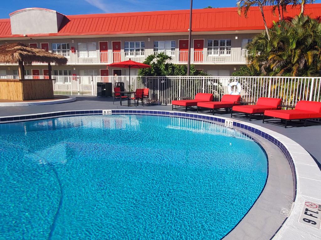 a large blue swimming pool in front of a hotel at Vero Beach Inn & Suites Vero Beach I-95 in Vero Beach
