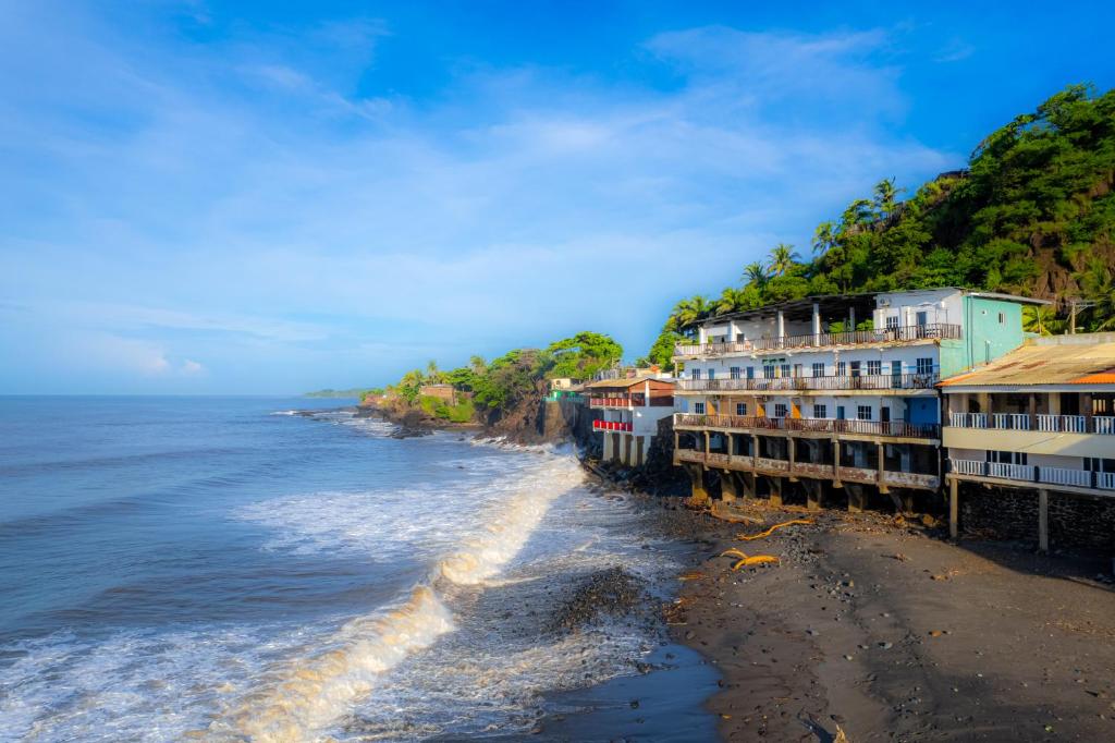 a row of buildings on a beach next to the ocean at Sunset View - Mini Loft in La Libertad