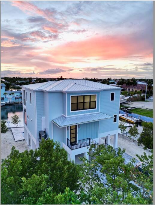 ein großes weißes Haus mit Sonnenuntergang im Hintergrund in der Unterkunft Newly built home in Cudjoe Key in Cudjoe Key