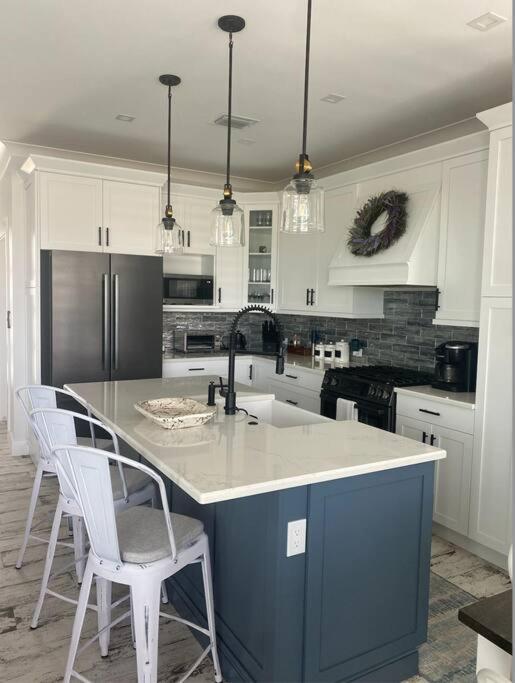 eine Küche mit einer blauen Insel und weißen Schränken in der Unterkunft Newly built home in Cudjoe Key in Cudjoe Key