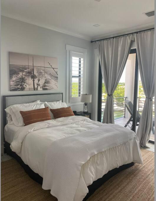 ein weißes Schlafzimmer mit großem Bett und Balkon in der Unterkunft Newly built home in Cudjoe Key in Cudjoe Key