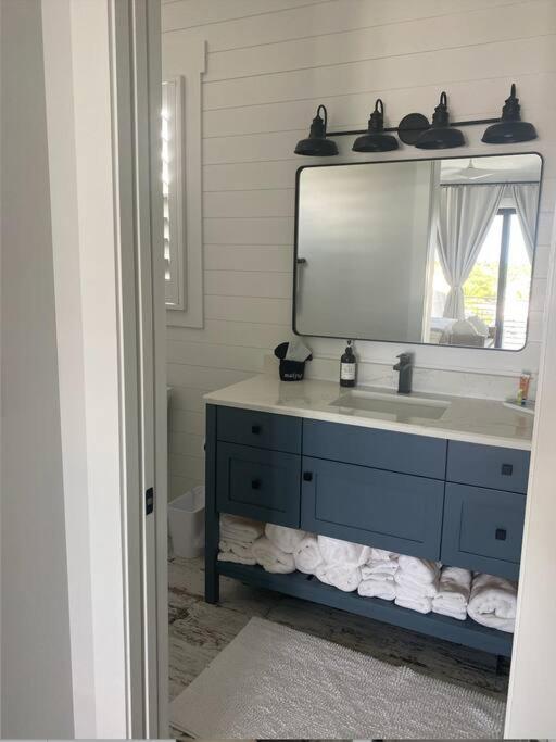ein Badezimmer mit einem blauen Waschbecken und einem Spiegel in der Unterkunft Newly built home in Cudjoe Key in Cudjoe Key