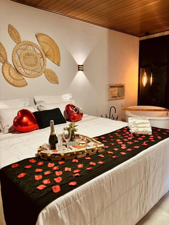 a bed with a table with a bottle of wine on it at Chalés Piribless-Ikigai in Pirenópolis