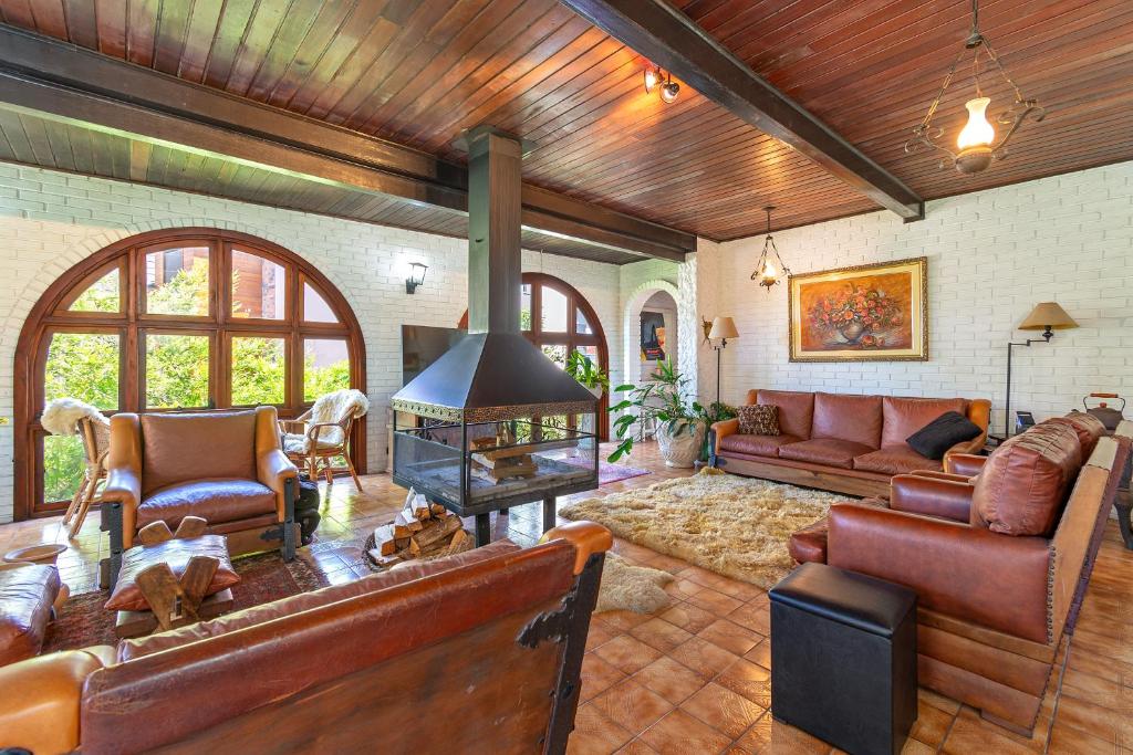 a living room with leather furniture and a fireplace at Casa Tissot- 5 Quartos no Centro de Gramado in Gramado