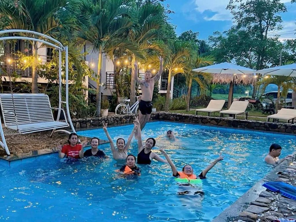 a group of people in the swimming pool at a resort at Palafita Bungalow in Phong Nha