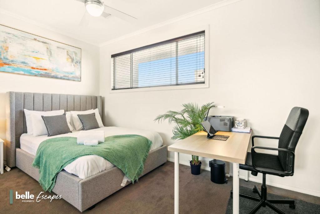 a bedroom with a bed and a desk and a chair at 3 BR Townhouse Near Airport-City-Beach in Thebarton