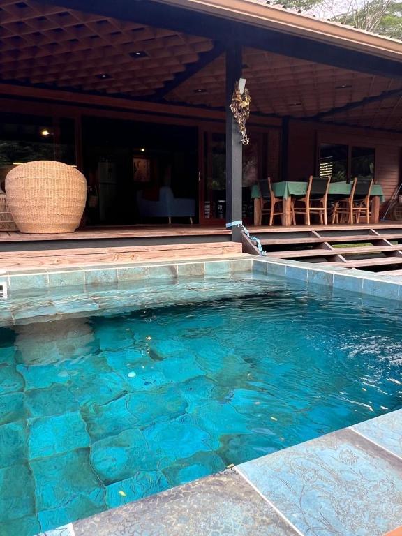una piscina di fronte a una casa di VILLA TEPUA a aUturoa