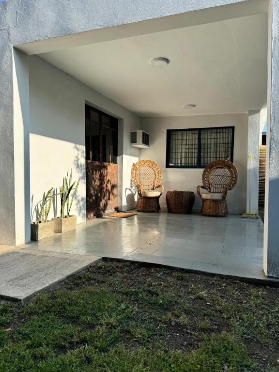 a living room with two chairs and a patio at Casa Milos para dos personas frente al rio in Santa Rosa de Calamuchita