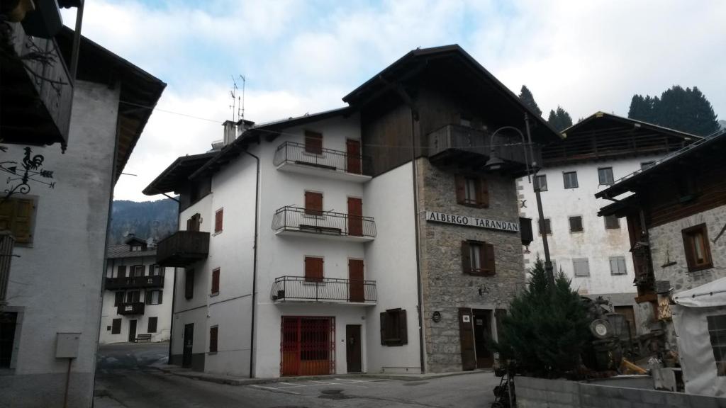 a white building with balconies on the side of it at Albergo Meuble Tarandan in Forni di Sopra