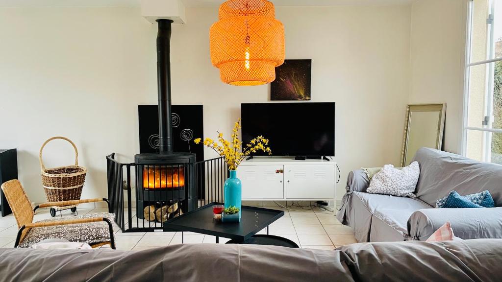 a living room with a couch and a fire place at La Mandragora - Maison avec jardin et poêle à bois in Vernon