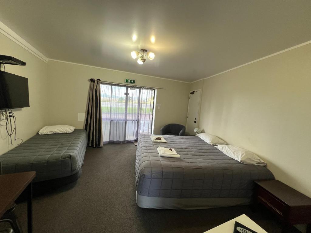 a hotel room with two beds and a window at Drury Motor Lodge in Drury