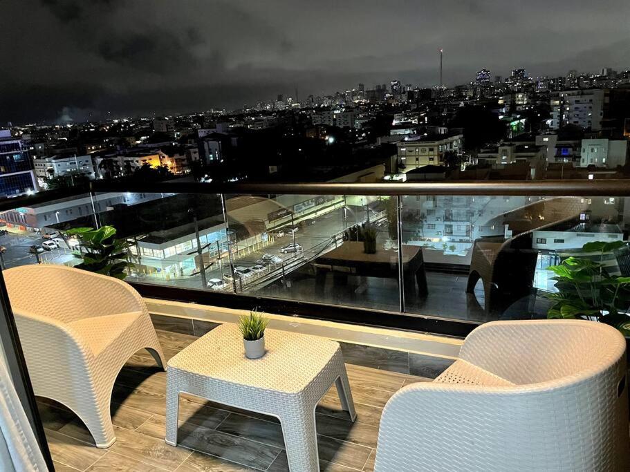 a balcony with chairs and a table and a view of a city at Luxury Santo Domingo Tower Condo in Santo Domingo