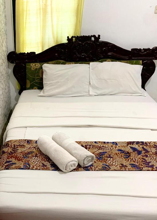 un letto con due asciugamani sopra di Sastro Inn Syariah Hotel Malioboro a Yogyakarta