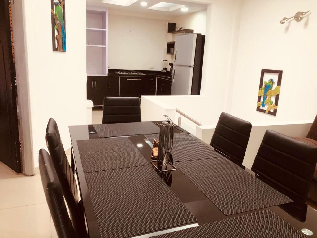 a dining room with a table and a kitchen at Casa privada en Montenegro Quindio in Montenegro