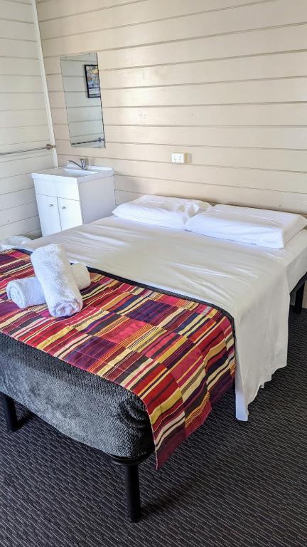 Postel nebo postele na pokoji v ubytování GRAND CENTRAL HOTEL PROSERPINE